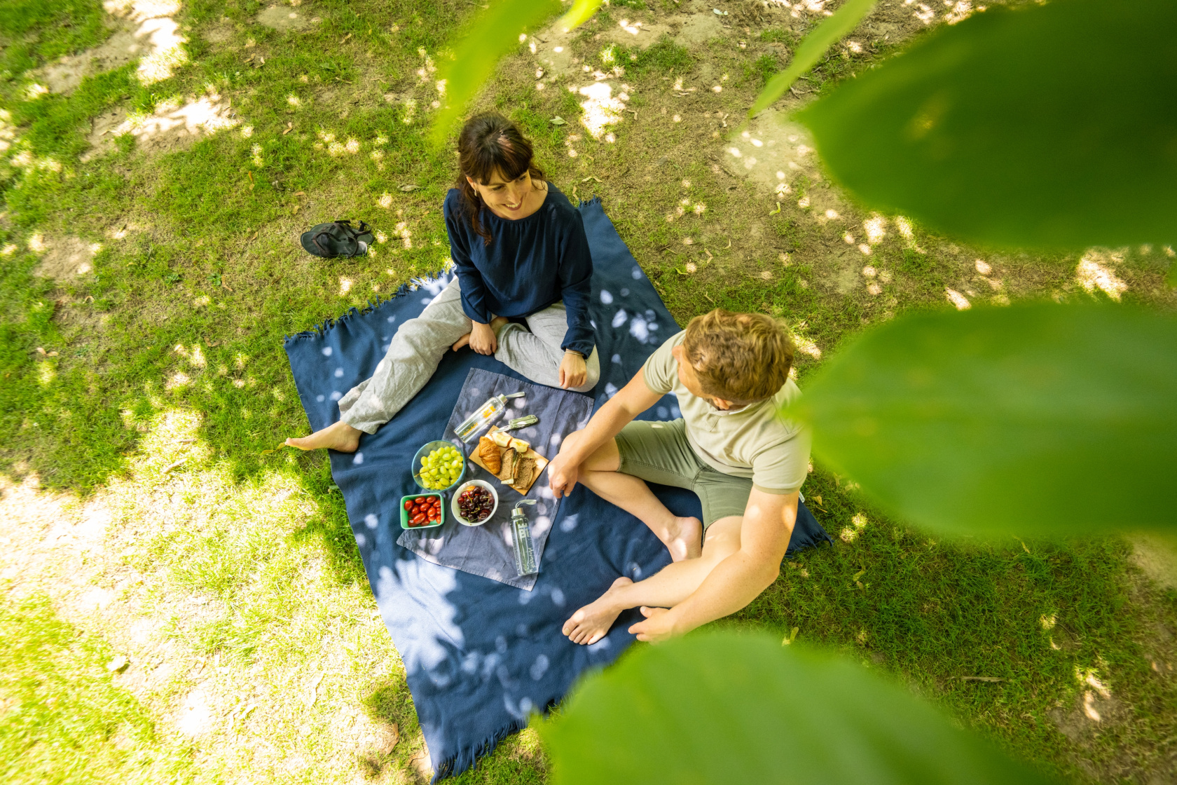 © Teutoburger Wald Tourimus | D. Ketz Mann und Frau sitzen auf einer Decke im Bürgerpark und Picknicken
