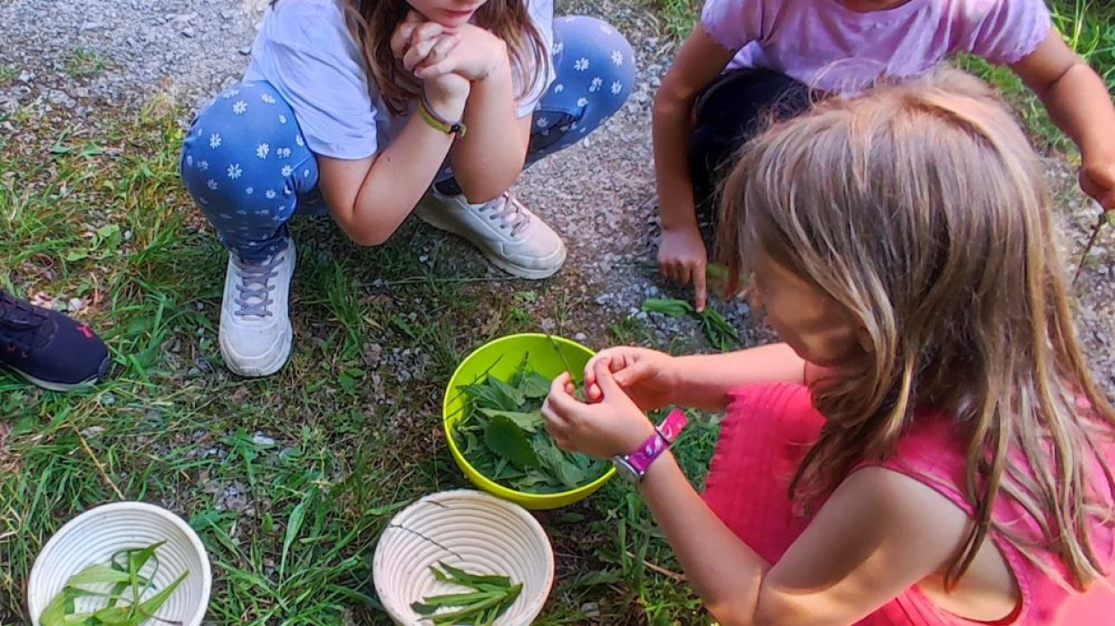 Kinder hockend vor Schalen mit Bohnen