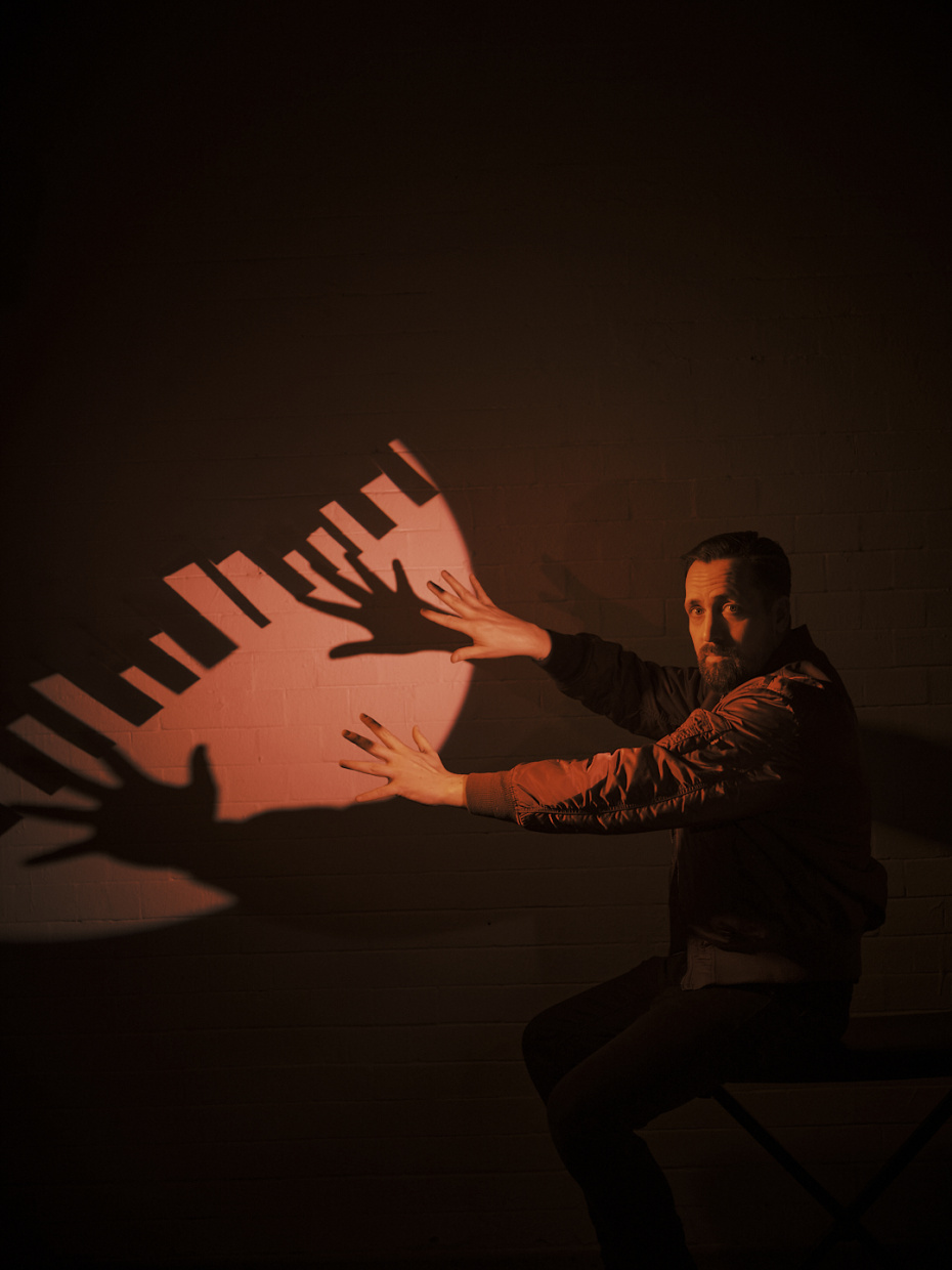 Musiker spielt Keyboard im warmen Bühnenlicht.