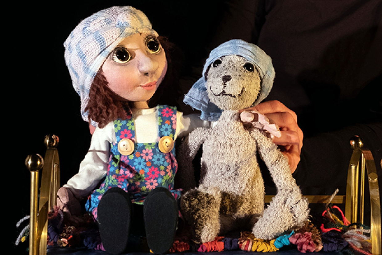 Kathi Braun und Stoffhase sitzen im Bett