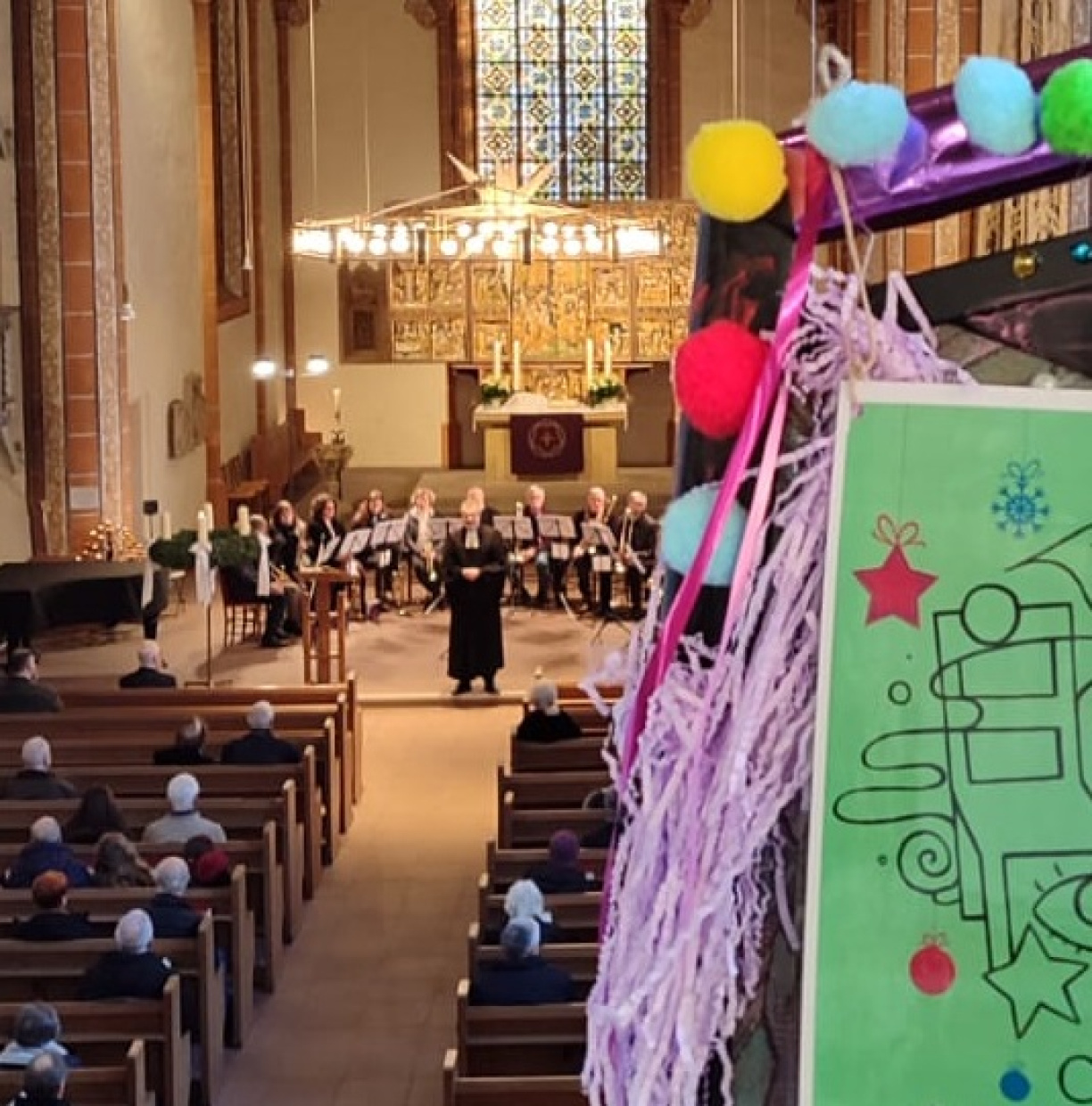 ein Stuhl mit einer Nummer im Anschnitt auf der Empore stehend, unten findet der Gottesdienst statt