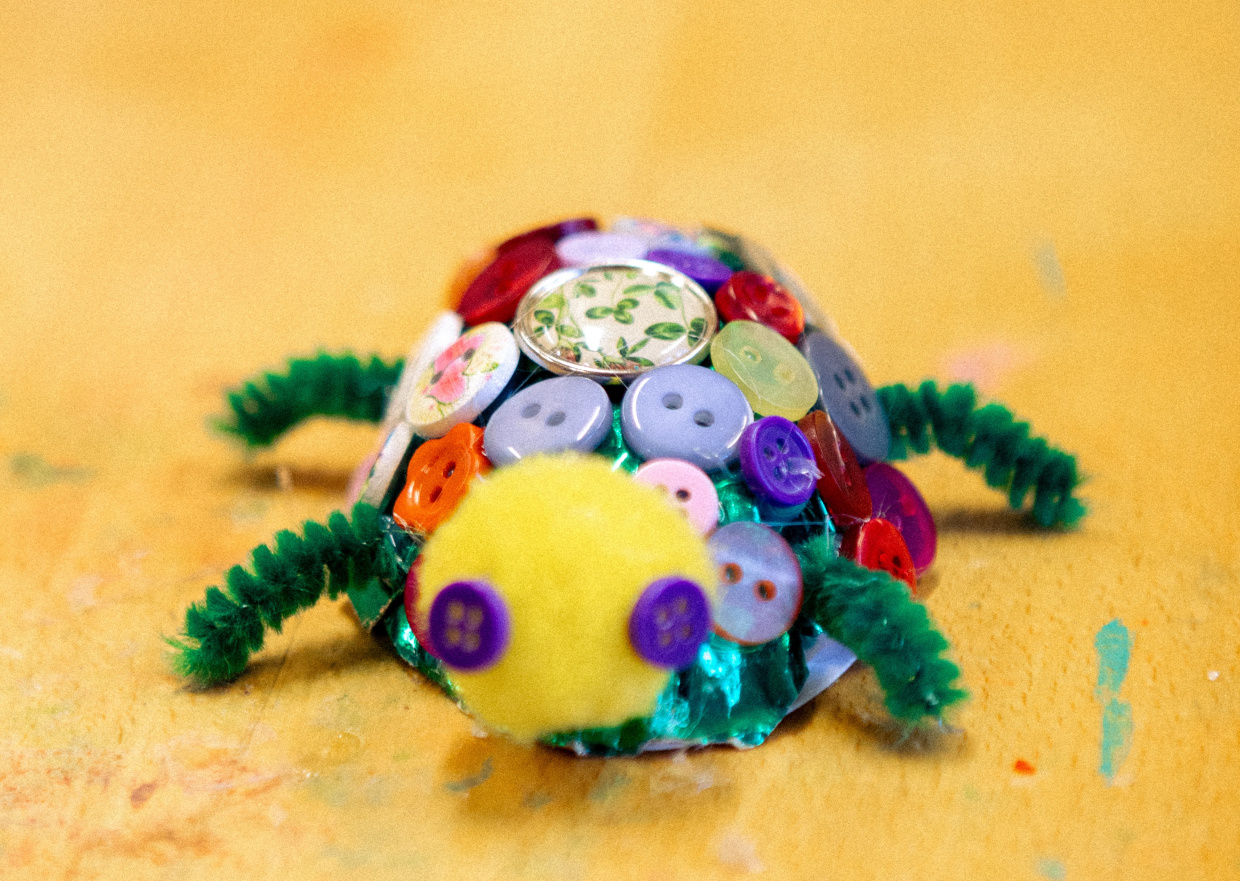 eine selbstgebastelte Schildkröte mit Panzer aus bunten Knöpfen