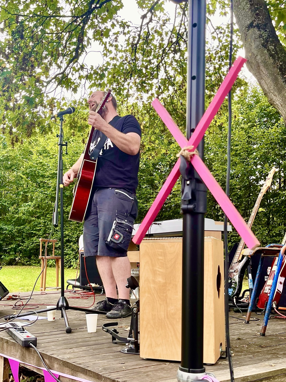 Gebäude der Rochdale Kaserne, pinkes Banner am Zaun und einige Menschen