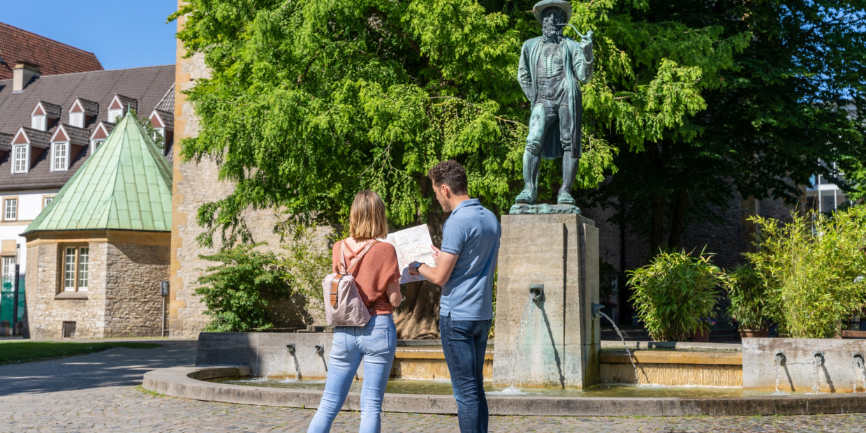 Mann und Frau stehen vor dem Leineweber-Denkmal