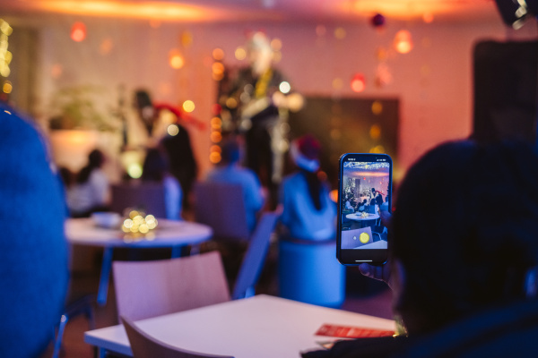 Blick in einen festlich geschmückten Raum, eine Person hält ein Handy, um die Deko zu fotografieren
