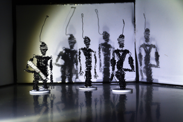 Fünf Schaufensterpuppen in Reihe, gekleidet in moderne Outfits mit Beleuchtung.