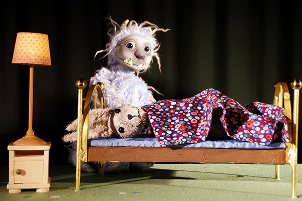 Ungeheuer steht vor einem Bett, in dem ein Hase liegt