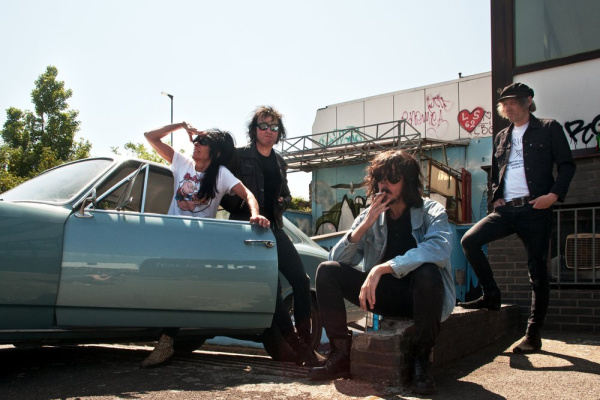 Die Band Gee Strings mit einen alten Opel im Hintergrund