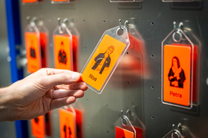 Hand hält orangefarbene Karte mit Spiel-Charakter darauf.